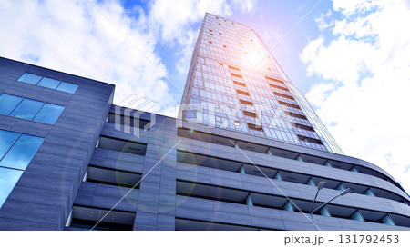 Exterior of a high modern multi-story apartment building - facade, windows and balconies. Timeless glass facade. Modern urban living district. 131792453