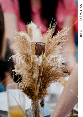 A bouquet of dried pampas grass and wheat flowers with a lotus flower in a vase 131794190