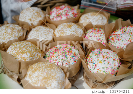 Lots of fresh Easter cakes with white icing and colorful sprinkles 131794211