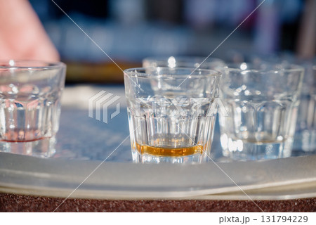 Close-up of glass shot glasses with alcohol on a tray 131794229