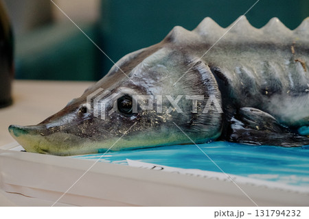 A close-up of a sturgeon-shaped birthday cake on a rectangular stand A close-up of a sturgeon-shaped birthday cake on a rectangular stand 131794232