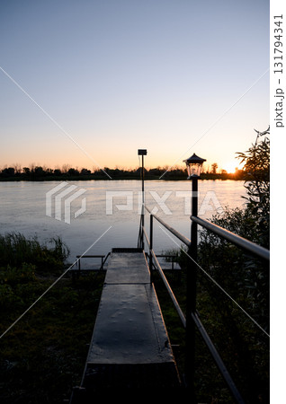 A pontoon deck or pier with a metal frame and railings near the water 131794341