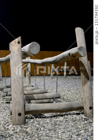 Children's playground with wooden swings and a slide at night. Children's playground with wooden swings and a slide at night. 131794392