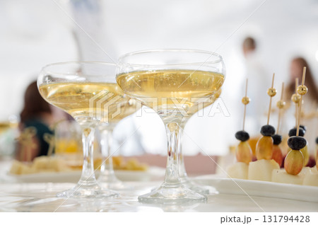 Close-up of glasses of champagne or sparkling wine and fruit canapes 131794428