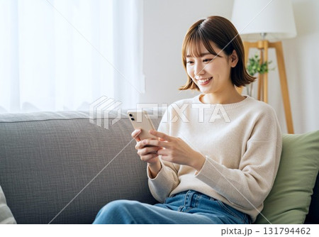 ソファに座ってスマホを見る女性 ソファに座ってスマホを見る女性 131794462