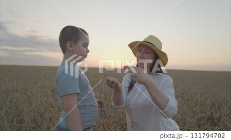 A Child Engaged in Learning in a Beautiful Wheat Field During a Breathtaking Sunset A Child Engaged in Learning in a Beautiful Wheat Field During a Breathtaking Sunset 131794702