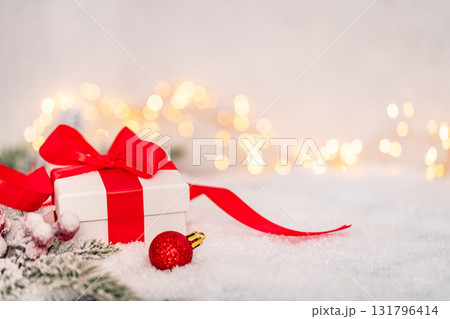 White Christmas Gift Box with Red Ribbon on Snowy Background White Christmas Gift Box with Red Ribbon on Snowy Background 131796414