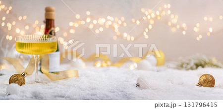 Champagne Glass and Bottle on Snow with Festive Lights Champagne Glass and Bottle on Snow with Festive Lights 131796415