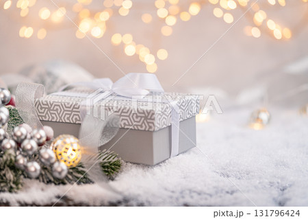 Elegant Gray Christmas Gift Box with White Ribbon on Snow Elegant Gray Christmas Gift Box with White Ribbon on Snow 131796424