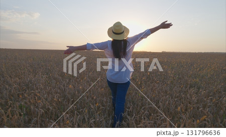 A Joyful and Relaxing Moment in a Beautiful Wheat Field Beneath a Gorgeous Sunset Sky 131796636