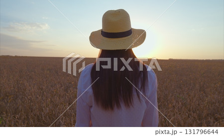 Breathtaking Serene Sunset in a Beautiful Wheat Field Featuring a Woman in a Stylish Sun Hat Breathtaking Serene Sunset in a Beautiful Wheat Field Featuring a Woman in a Stylish Sun Hat 131796644