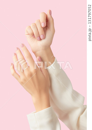 Beautiful groomed womans hands with pink matte nail design on a pink background 131797052