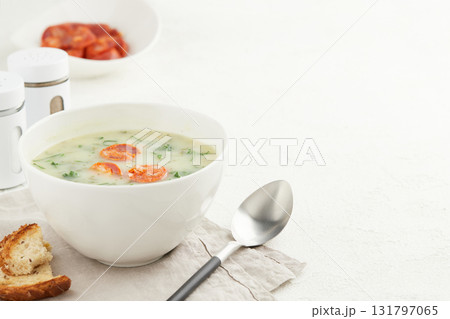 Typical Portuguese soup Caldo Verde with bread and chorizo sausage on white background 131797065