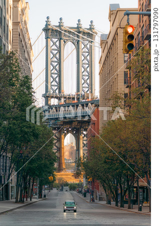 Green SUV car drives down a street towards the Manhattan Bridge. Green SUV car drives down a street towards the Manhattan Bridge. 131797090