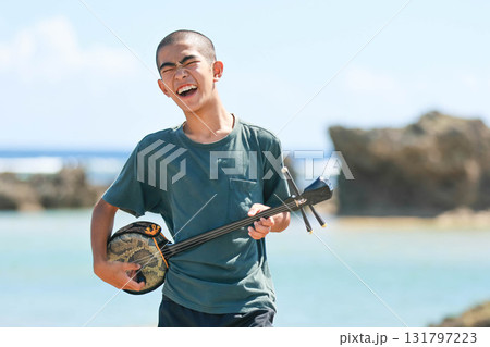 沖縄の海岸で三線を奏でる沖縄の島人 131797223