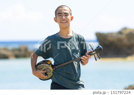 沖縄の海岸で三線を奏でる沖縄の島人 131797224