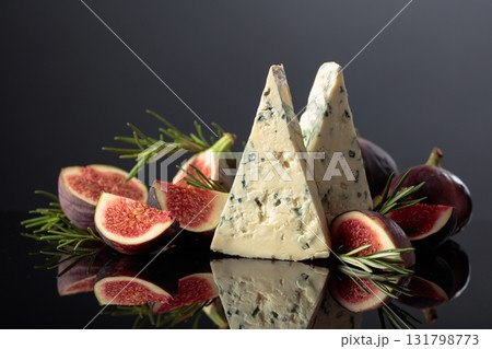 Blue cheese with fresh figs and rosemary on a black background. Blue cheese with fresh figs and rosemary on a black background. 131798773