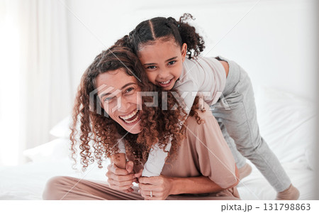 Portrait, mother and girl on bed, piggy back and smile with joy, bonding and quality time. Face, mama carry daughter or happiness in bedroom, loving or interracial with female child, kid or mom relax Portrait, mother and girl on bed, piggy back and smile with joy, bonding and quality time. Face, mama carry daughter or happiness in bedroom, loving or interracial with female child, kid or mom relax 131798863