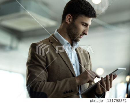 Technology, internet and businessman with tablet reading email, sales report or website statistics. Research, leadership and company ceo networking, online communication management at startup office. 131798871