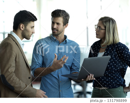 Laptop, collaboration and meeting with a business team talking in the office for planning or strategy. Computer, teamwork or discussion with a man and woman employee group chatting about work 131798899