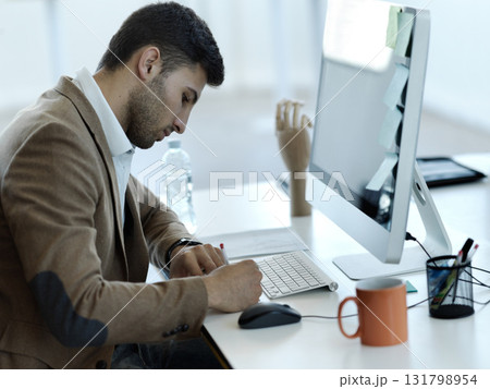 Research, computer and writing with businessman in office for web design, analytics and planning. Schedule, technology and internet with person in digital agency for idea, advertising and agenda 131798954