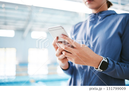 Hands, phone and athlete texting at swimming pool for social media, web scrolling or online browsing after exercise. Swim sports, cellphone and woman typing on internet chat after workout or training 131799009