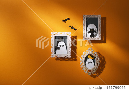 Handmade paper craft for Halloween. Yellow wall with portraits of ghosts with cats and bats. Space for your text. Handmade paper craft for Halloween. Yellow wall with portraits of ghosts with cats and bats. Space for your text. 131799063