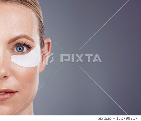 Skincare mask, eyes and portrait of woman on gray background for wellness, cosmetics and facial care. Salon mockup space, dermatology and half face with pads for anti aging, makeup and beauty product 131799217