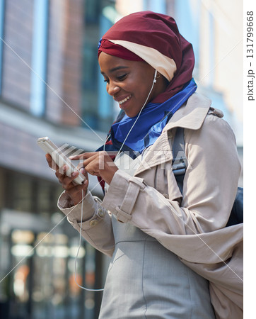 Black woman, phone and smile listening to music in the city for communication, social media or chat. African American and independent girl typing on smartphone with 5G connection, app and earphones Black woman, phone and smile listening to music in the city for communication, social media or chat. African American and independent girl typing on smartphone with 5G connection, app and earphones 131799668