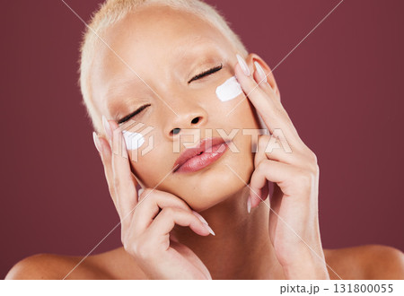 Face cream, eyes closed and beauty skincare of woman in studio isolated on a red background. Dermatology aesthetic, cosmetics and female model apply lotion, creme and moisturizer for facial treatment 131800055