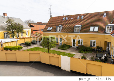 Yellow residential building with a yard on a sunny day. Yellow residential building with a yard on a sunny day. 131800119