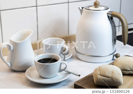 Breakfast served on the kitchen table with fresh bread and coffee 131800126