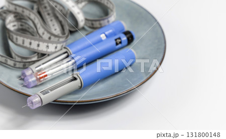 Ozempic Insulin injection pen for diabetics and weight loss on a plate with a measuring tape Ozempic Insulin injection pen for diabetics and weight loss on a plate with a measuring tape 131800148