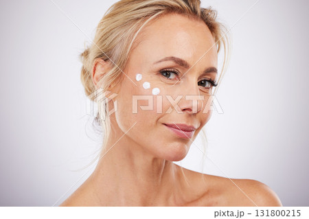 Portrait, skincare and face cream for mature woman in studio for wellness, hydration and care on grey background. facial, product or sunscreen for lady relax in luxury, cosmetic and moisture isolated Portrait, skincare and face cream for mature woman in studio for wellness, hydration and care on grey background. facial, product or sunscreen for lady relax in luxury, cosmetic and moisture isolated 131800215