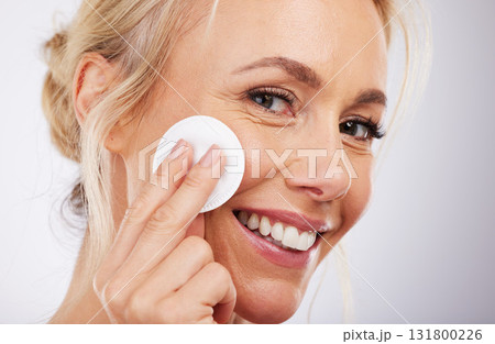 Mature, facial and cotton in studio for skincare, wellness and cleaning routine on grey background. Face, skin and pad by older beauty model relax in luxury, dermatology or cosmetic grooming isolated 131800226