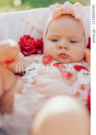 Cute baby girl sitting in bathtub filled with red roses flowers.Beauty innocence Cute baby girl sitting in bathtub filled with red roses flowers.Beauty innocence 131800340