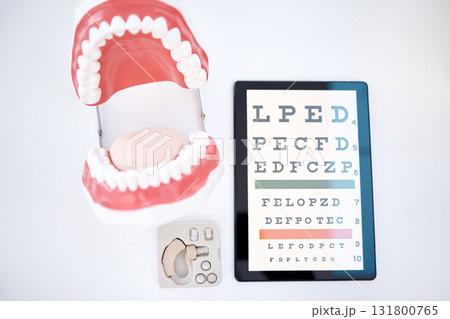 Dental, optometry and otolaryngology equipment to examine, diagnose and test isolated in a studio white background. Mouth, hearing aid and an optotype or eye chart for healthcare, medical or wellness 131800765