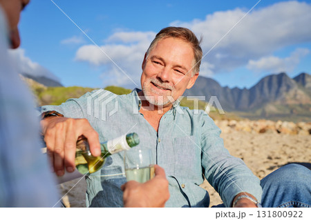 Love, wine and happy with old couple on beach for celebration, anniversary and romantic date. Smile, relax and sunset with man pouring champagne for woman for vacation, summer break or travel holiday 131800922
