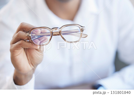 Glasses, optometry and hand of optometrist holding spectacles, eyewear or specs for ophthalmology in an office. Person, eye care and doctor or professional with a vision frame by medical employee Glasses, optometry and hand of optometrist holding spectacles, eyewear or specs for ophthalmology in an office. Person, eye care and doctor or professional with a vision frame by medical employee 131801840