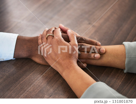 Support, help and couple holding hands for trust, empathy and unity in crisis, cancer or bad news. Solidarity, care and man and woman together on table for praying, comfort and prayer, hope or love. 131801870