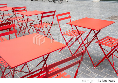 City cafe on the open air. Red metal chairs and tables outside with summer sun weather on the street. Design of furnitureset for summer cafe or restaurant. City cafe on the open air. Red metal chairs and tables outside with summer sun weather on the street. Design of furnitureset for summer cafe or restaurant. 131801983