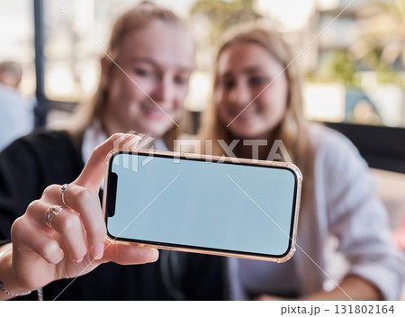 Selfie, showing and friends with mockup phone for advertising a brand at a restaurant. Marketing, contact and hands of women with a blank mobile screen for a photo, show app and social media at cafe 131802164