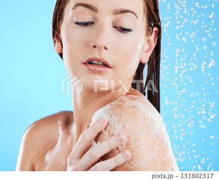 Shower soap, woman and body cleaning in a studio with a female washing for beauty routine. Water, model and wellness of a young person in bathroom for self care and dermatology with blue background Shower soap, woman and body cleaning in a studio with a female washing for beauty routine. Water, model and wellness of a young person in bathroom for self care and dermatology with blue background 131802317