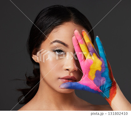 Beauty, woman and face, paint on palm with art, colorful aesthetic and makeup with color in portrait on studio background. Skin, glow and cosmetics, creativity and female hand with artistic 131802410