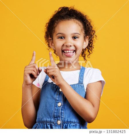 Portrait, pointing up and girl with smile, branding development and happiness against a studio background. Face, female child and young person gesture for space, direction and showing with choice 131802425
