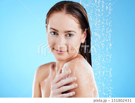 Shower, water and woman portrait washing in studio for skincare, wellness and clean body or self care. Happy female, splash or drops for cleaning, soap mockup space and hygiene on blue background 131802431