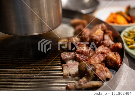 Samgyupsal, a popular Korean dish consisting of thick, sliced pork belly cooked on the grill Samgyupsal, a popular Korean dish consisting of thick, sliced pork belly cooked on the grill 131802494