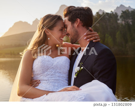 Intimate, love and couple at their wedding by the lake with affection moment together in nature. Happiness, smile and young groom and bride on their romantic outdoor marriage day ceremony by forest. Intimate, love and couple at their wedding by the lake with affection moment together in nature. Happiness, smile and young groom and bride on their romantic outdoor marriage day ceremony by forest. 131802809
