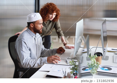 Muslim, islamic and diverse colleagues working together on a computer planning a web design at a startup company. Office, diversity and business man with woman doing job online, website and internet Muslim, islamic and diverse colleagues working together on a computer planning a web design at a startup company. Office, diversity and business man with woman doing job online, website and internet 131802936
