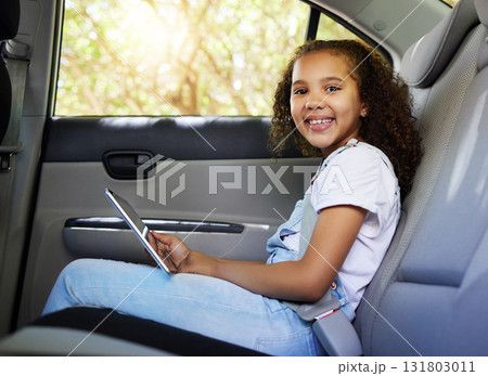 Car ride, child portrait and tablet with a happy kid in a backseat with transportation travel. Video streaming, smile and happiness of a girl on road trip and adventure for holiday riding in vehicle Car ride, child portrait and tablet with a happy kid in a backseat with transportation travel. Video streaming, smile and happiness of a girl on road trip and adventure for holiday riding in vehicle 131803011